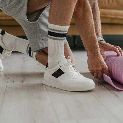 Close-up of athletic shoes on a yoga mat before a workout.