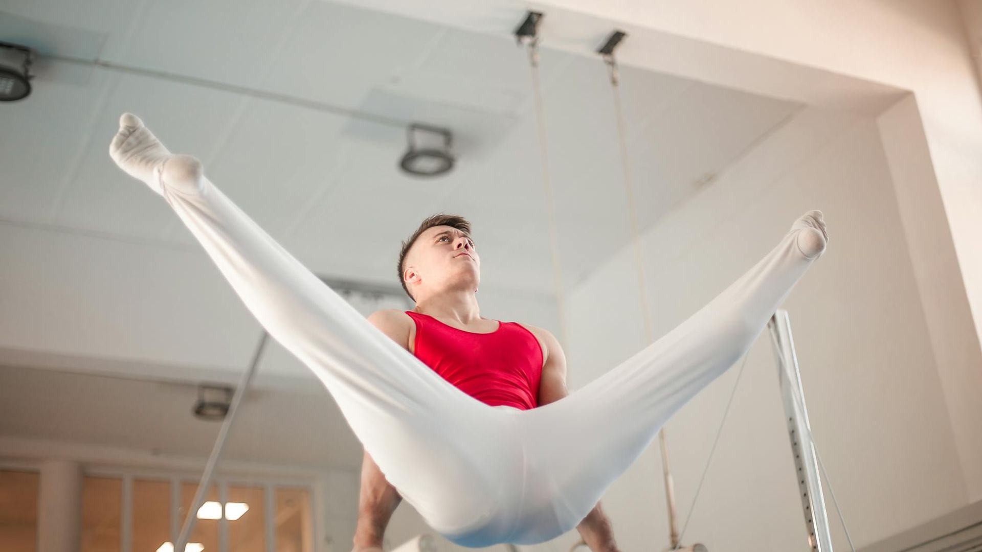 Man performing a controlled bodyweight exercise in a minimalist gym.